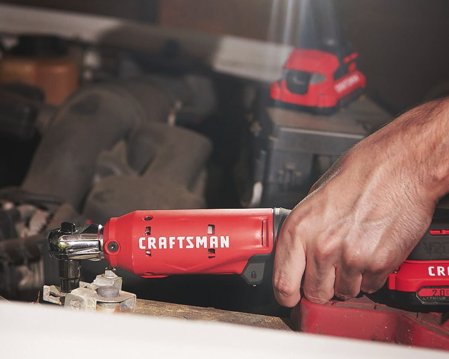 Photo of Craftsman cordless ratchet CMCF930B in use on an engine part, red tool body with visible brand logo.