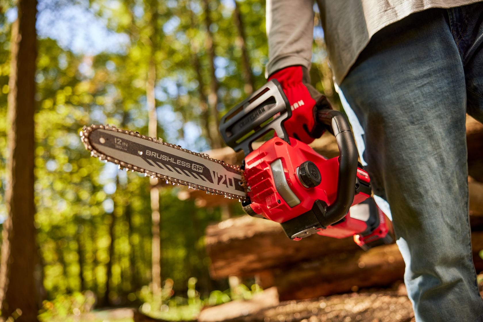 Photo of Craftsman 12-inch brushless cordless chainsaw CMCCS630B being held outdoors, showing side view.