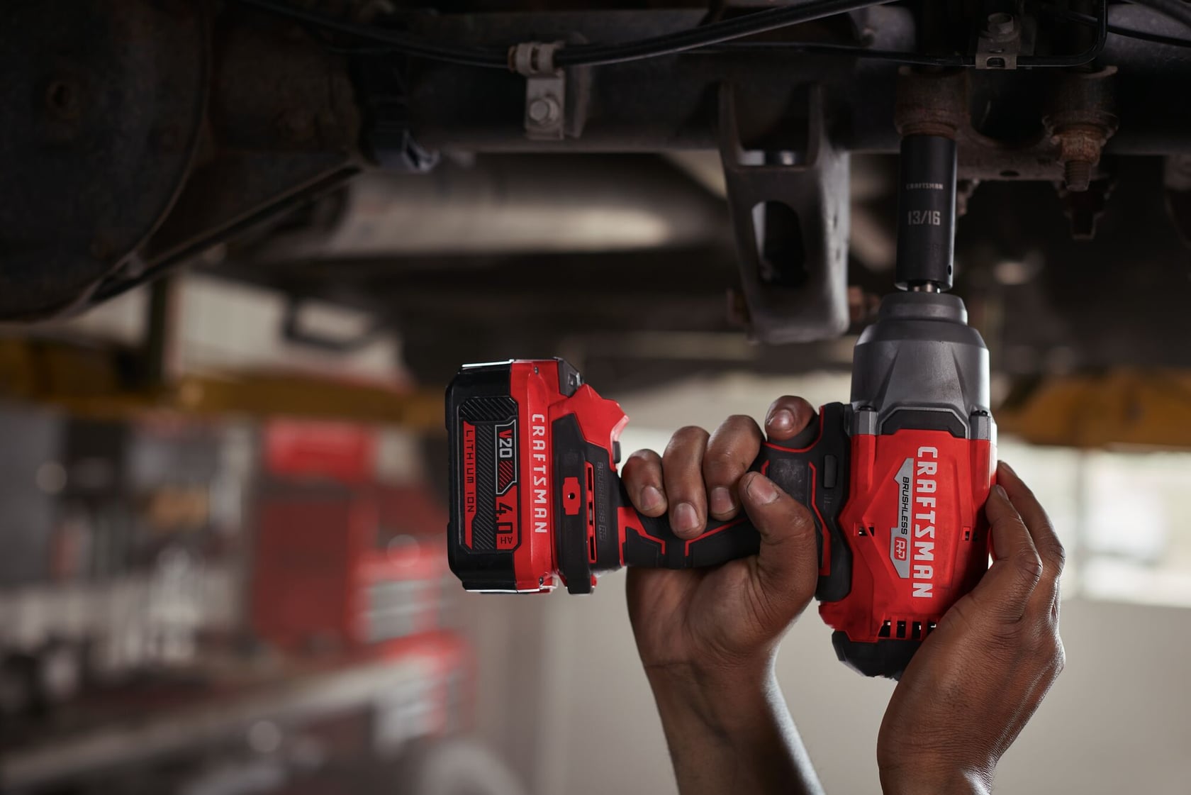 Photo of Craftsman cordless impact wrench CMCF940M1 in use, red and black design, automotive repair setting.