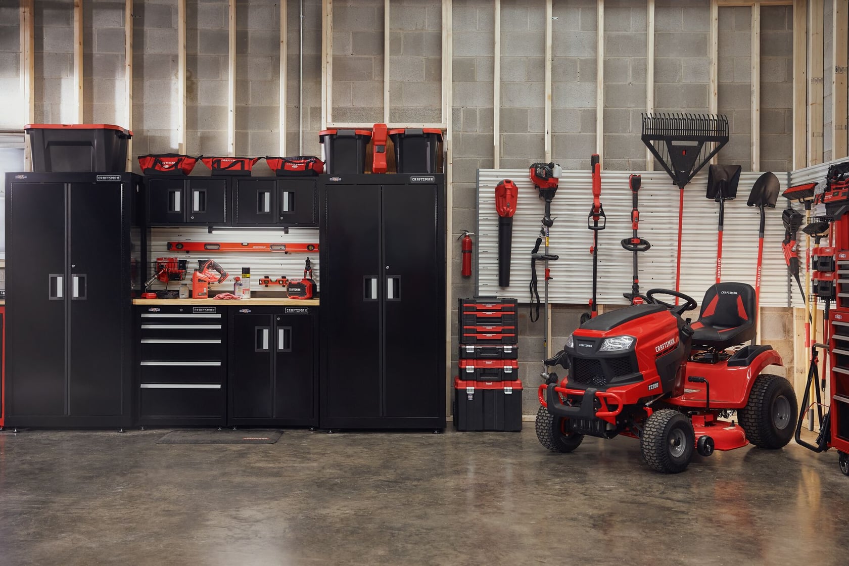 Photo of Craftsman CMCBL700D1 riding mower in garage with Craftsman tool cabinets and garden tools.
