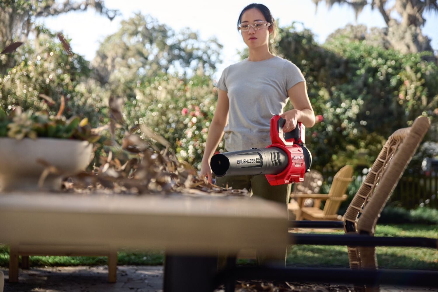 Photo of Craftsman brushless cordless leaf blower CMCBL730P1 in use clearing leaves from outdoor table.