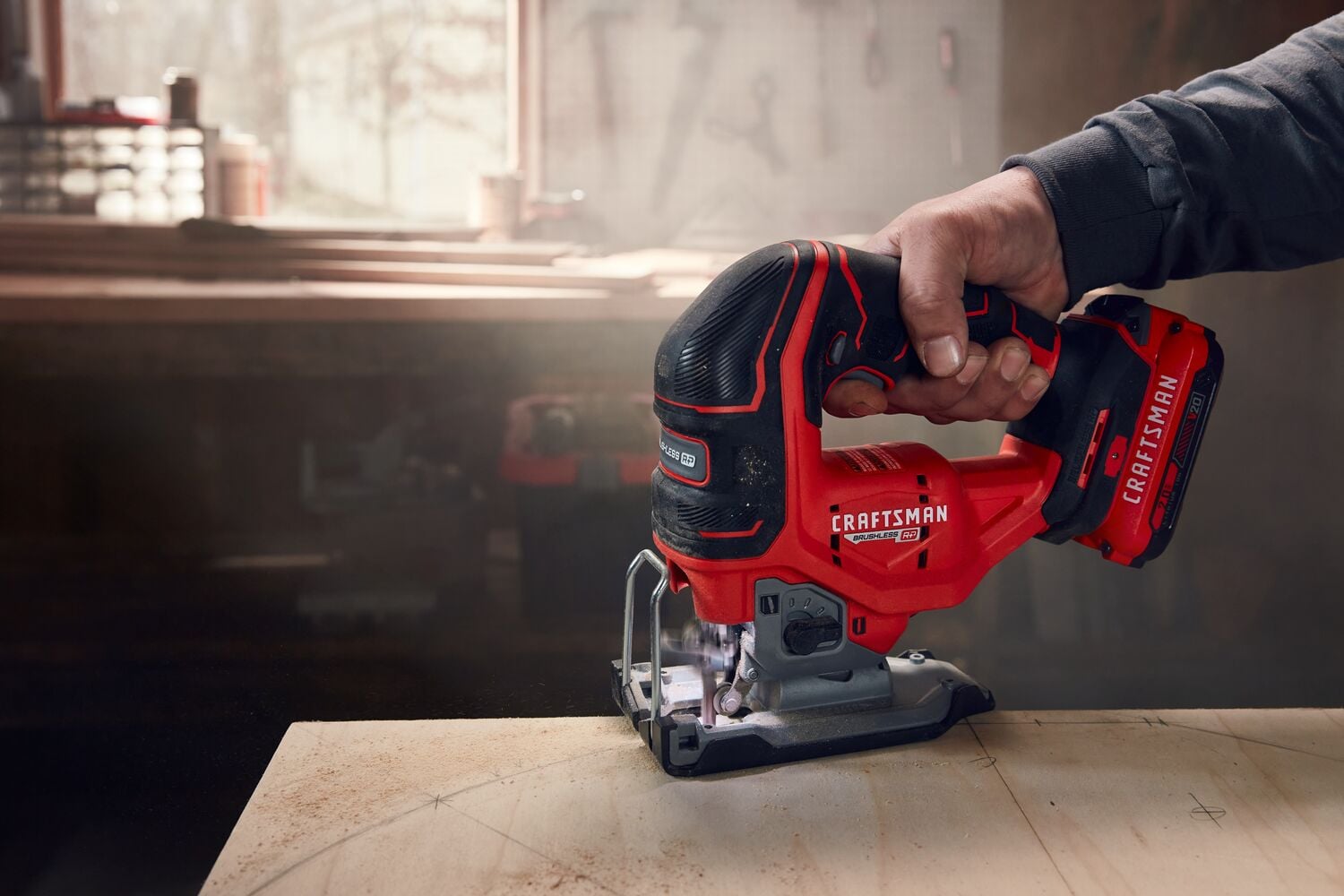 Photo of a Craftsman cordless jigsaw, SKU CMCS650B, in use cutting wood in a workshop setting.