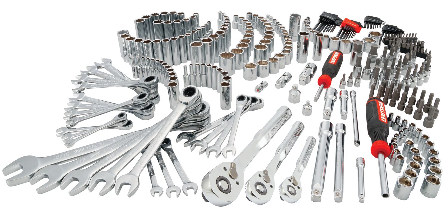 A large assorted mechanic tool set displayed on a white background, including wrenches, ratchets, sockets, hex keys, screwdrivers, and various attachments. The tools are organized by type and size, and most are metallic with some handles featuring red and black accents.