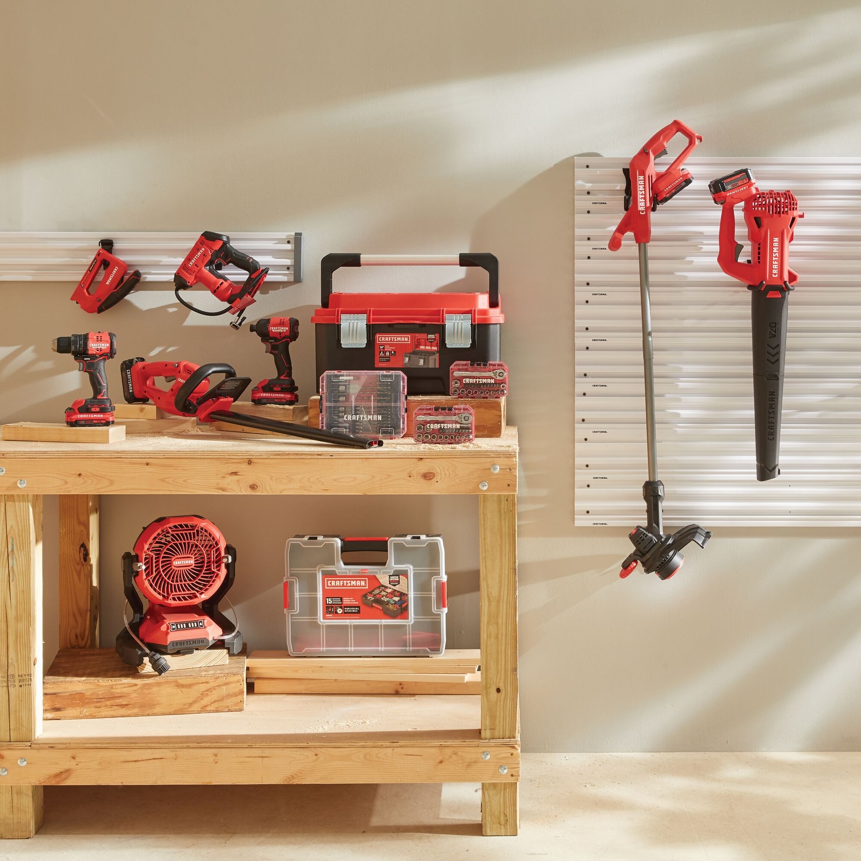 A collection of red CRAFTSMAN power tools and accessories displayed in a well-lit workshop. The tools include drills, saws