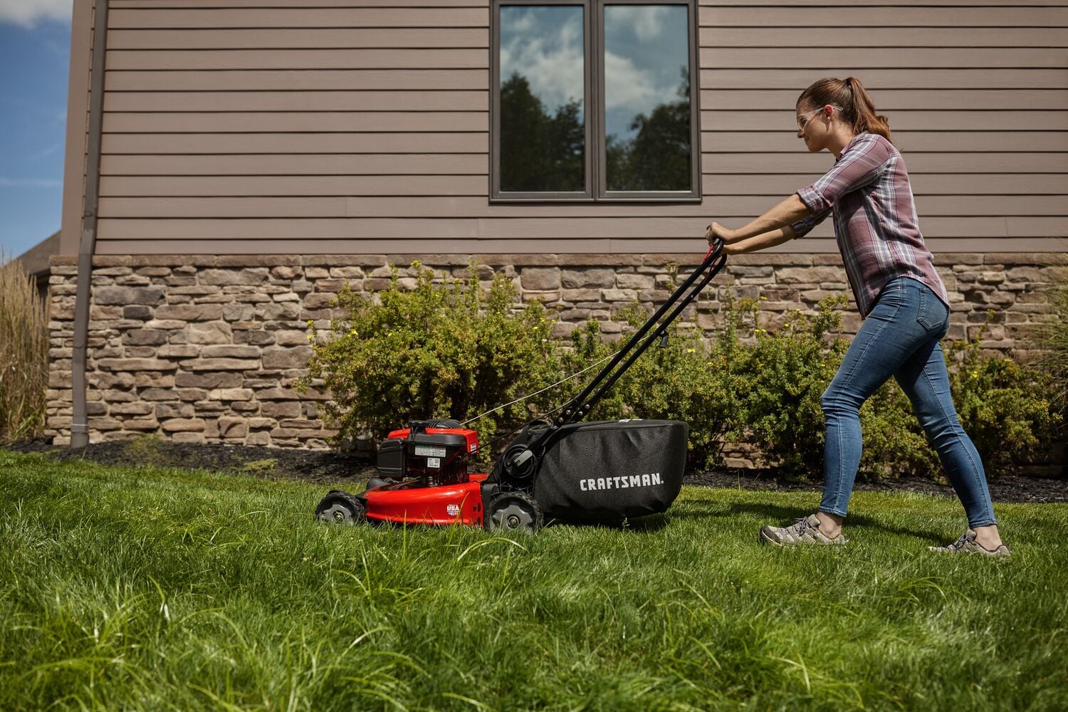 Photo of CRAFTSMAN M160 lawn mower 11A-U2BV793 in use outdoors on grass, side view.