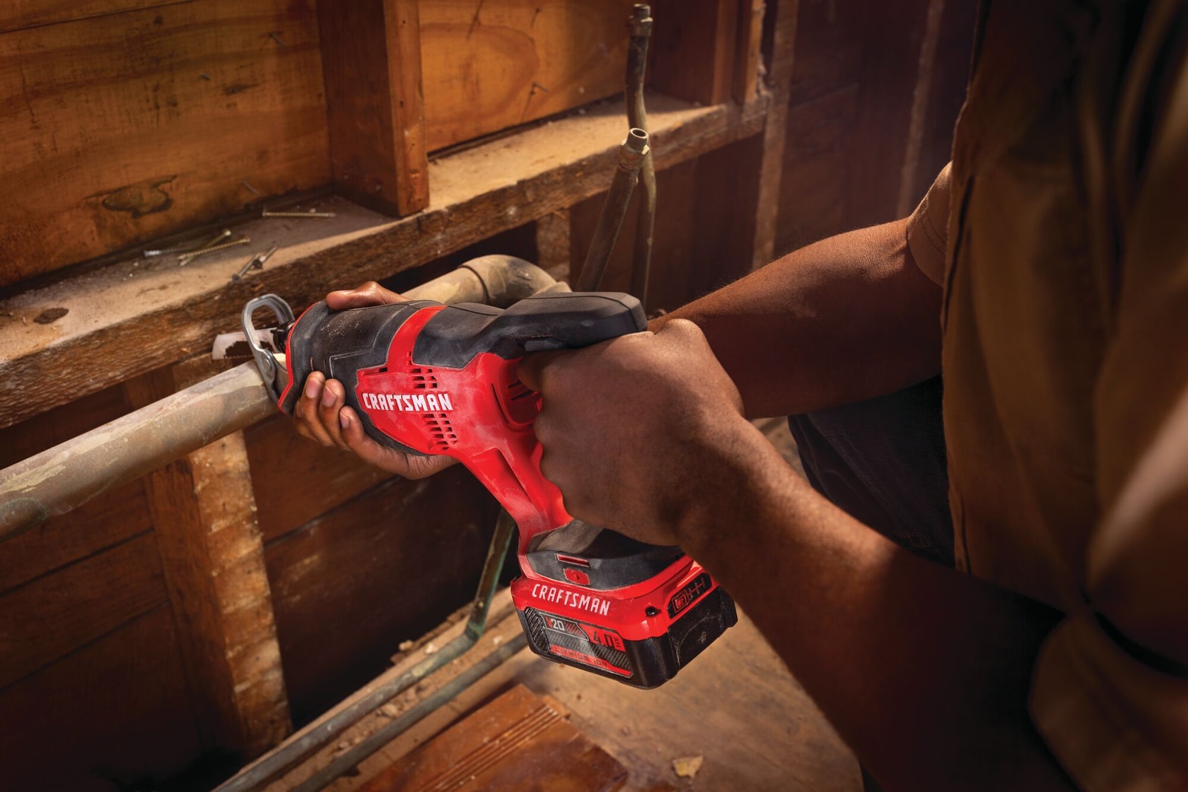 20 volt cordless reciprocating saw kit being used by a person to cut a steel pipe.