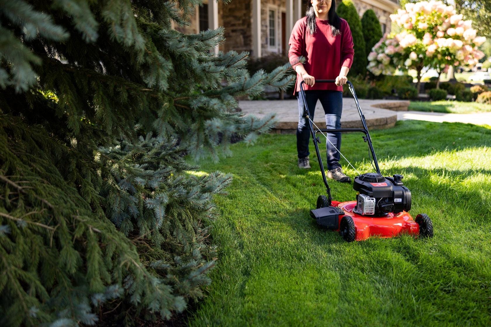 Front view of woman cutting grass with M090 Walk-behind Lawn Mower