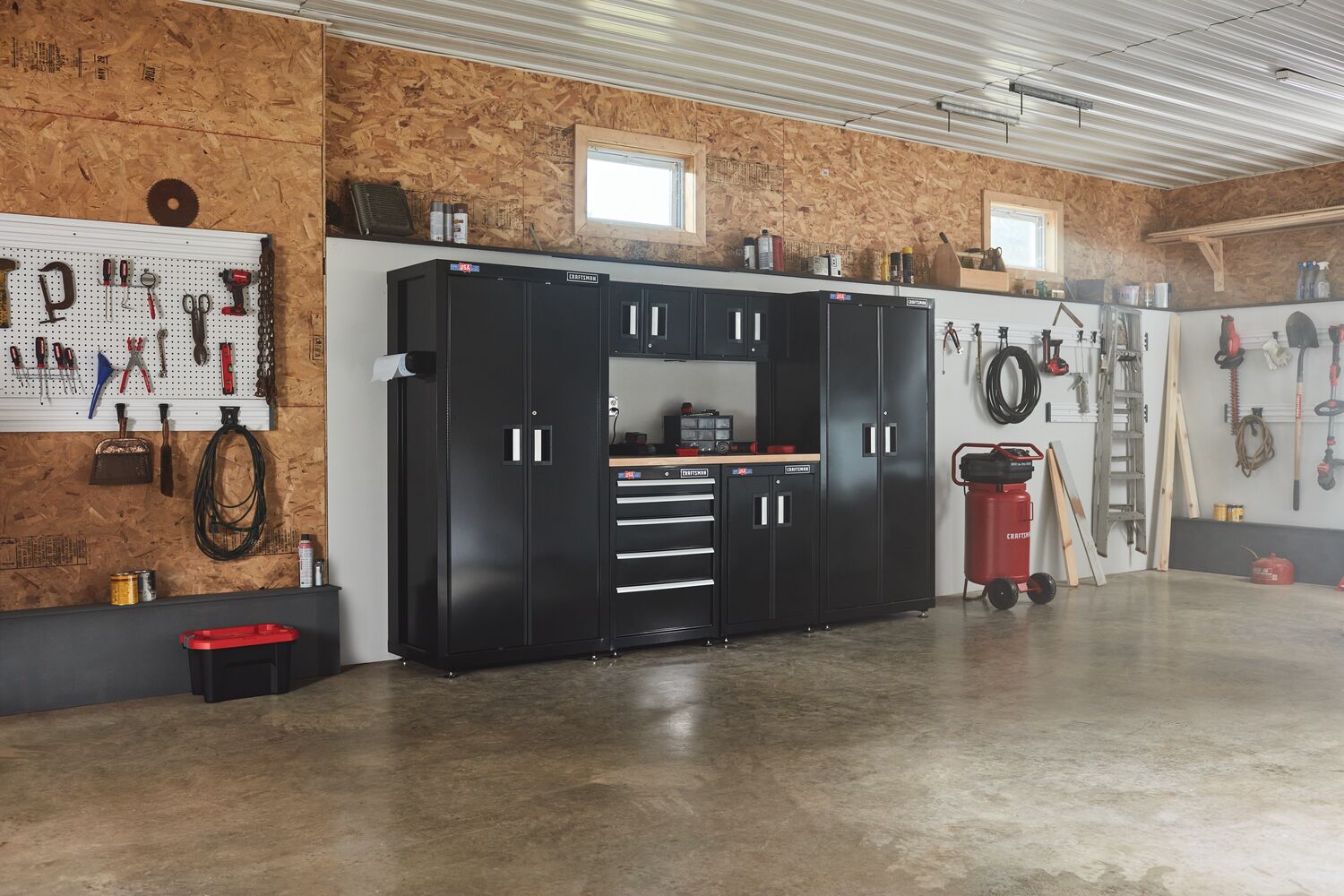 126 inch Wide 7 Piece Welded Metal Storage Suite With Cabinet and Drawer Storage placed in a garage workshop along with variety of other tools and equipment.