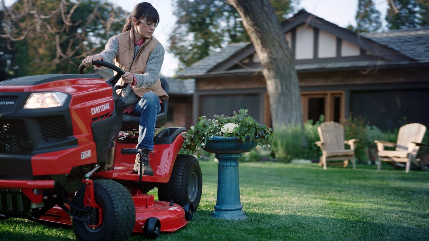 46 inch 22 h p hydrostatic riding mower with turn tight being used by a person to mow the lawn beside a fountain.